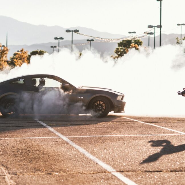 person riding on gray coupe doing drifting