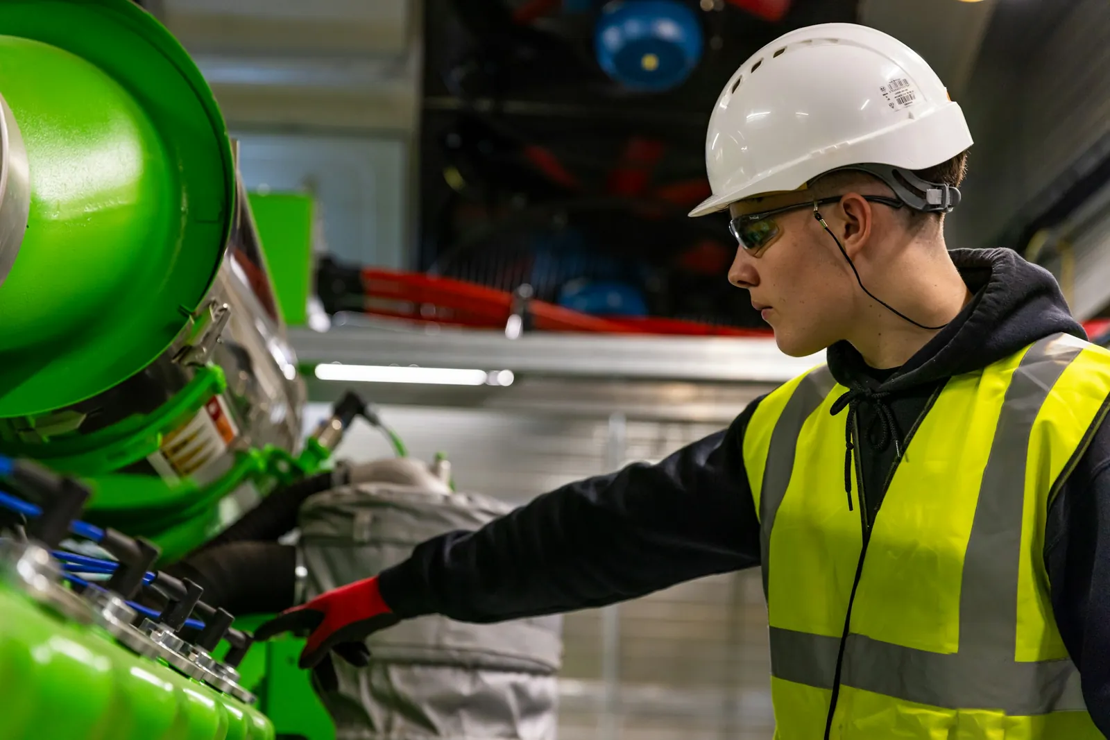Técnico con casco revisando válvulas y cañerías en una planta industrial